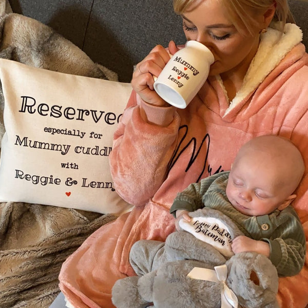 Mum sat with baby whilst drinking from personalised mug wearing sherpa